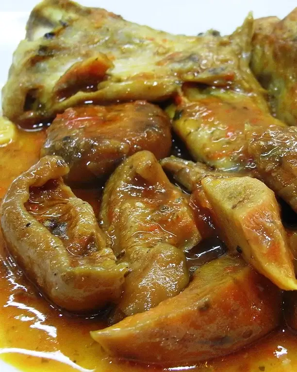 Conill guisat amb rovellons en una salsa ataronjada, de prop.