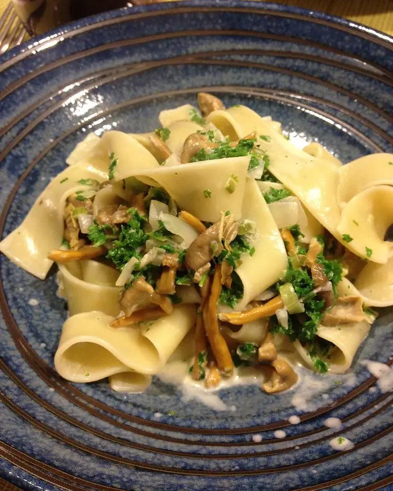 Pappardelle amb camagrocs, porro i julivert en un plat de ceràmica blava.